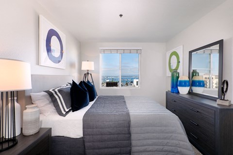 A bedroom with a large bed and a view of the city.