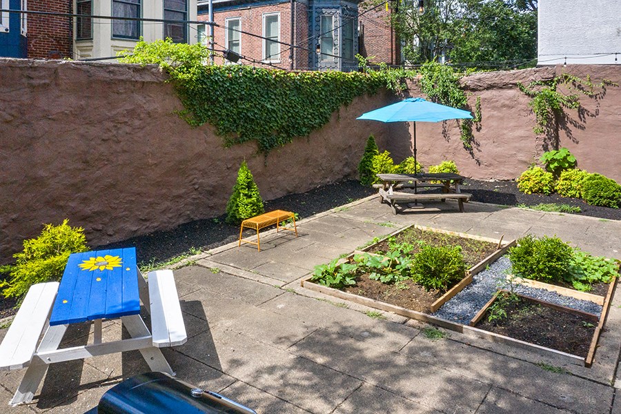 a small patio with an umbrella and a picnic table