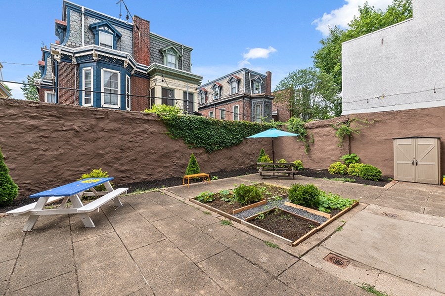 the backyard has a patio with a picnic table and an umbrella