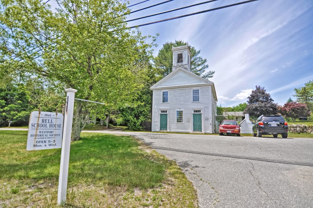 a white church with a sign on the side of a road