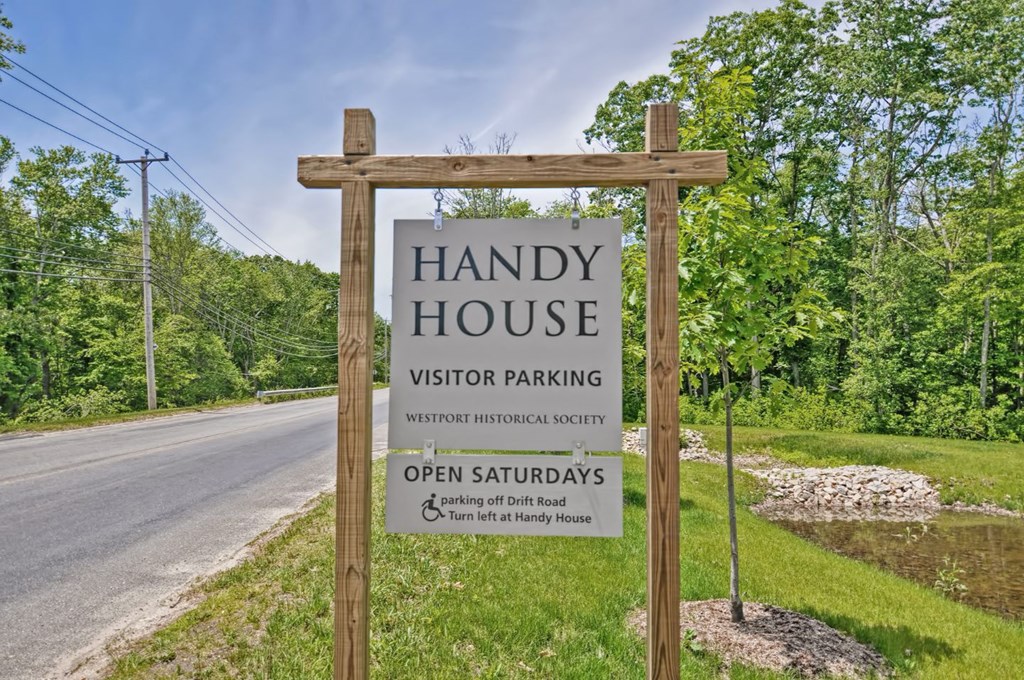 a sign for handy house visitor parking at the side of a road