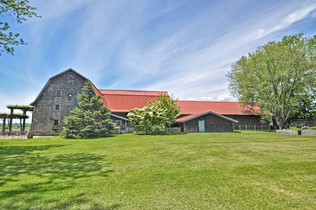 a barn with a red roof and a grassy field