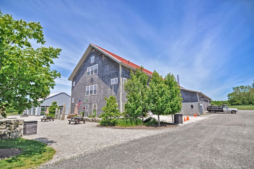 a house with a gravel driveway and trees in front of it