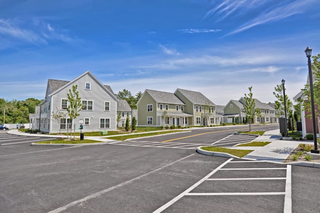 an empty parking lot in front of a row of houses