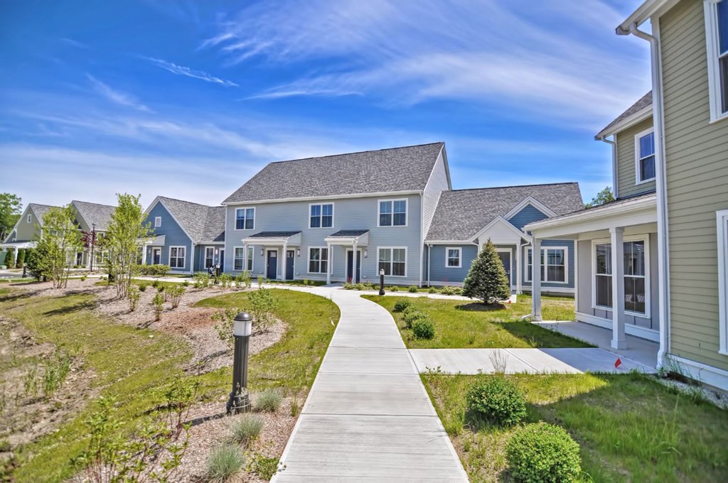 a row of houses with a sidewalk in front of them
