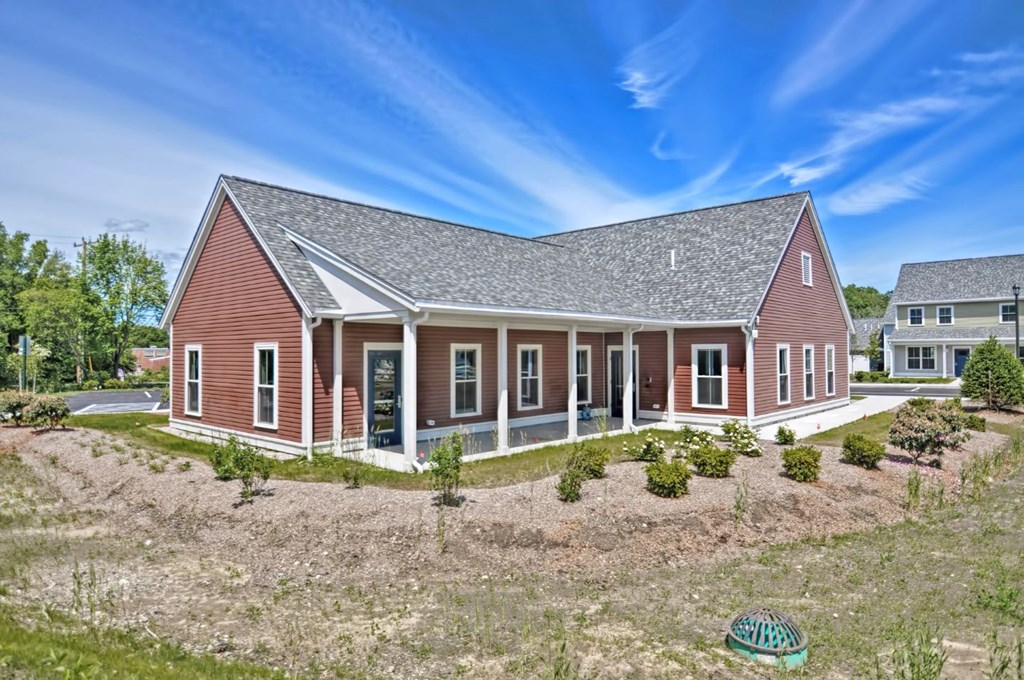 a red house with a gray roof and a yard in front of it