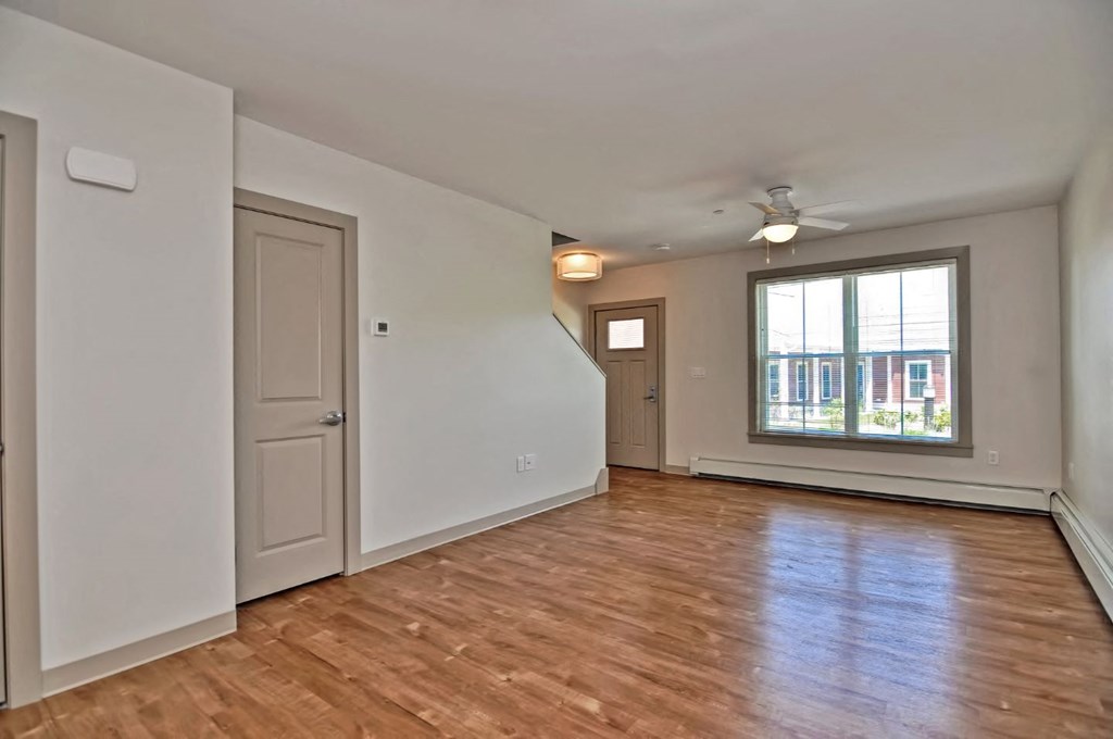 an empty living room with white walls and a window