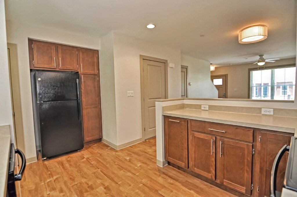 a kitchen with wooden cabinets and a black refrigerator
