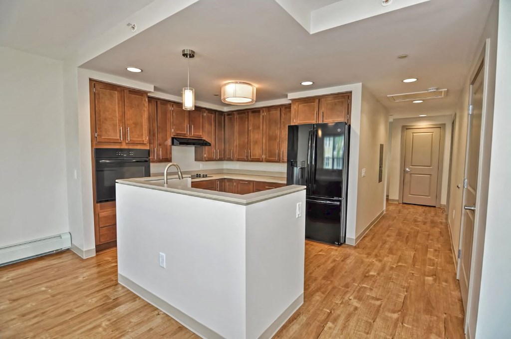 a kitchen with an island and a black refrigerator