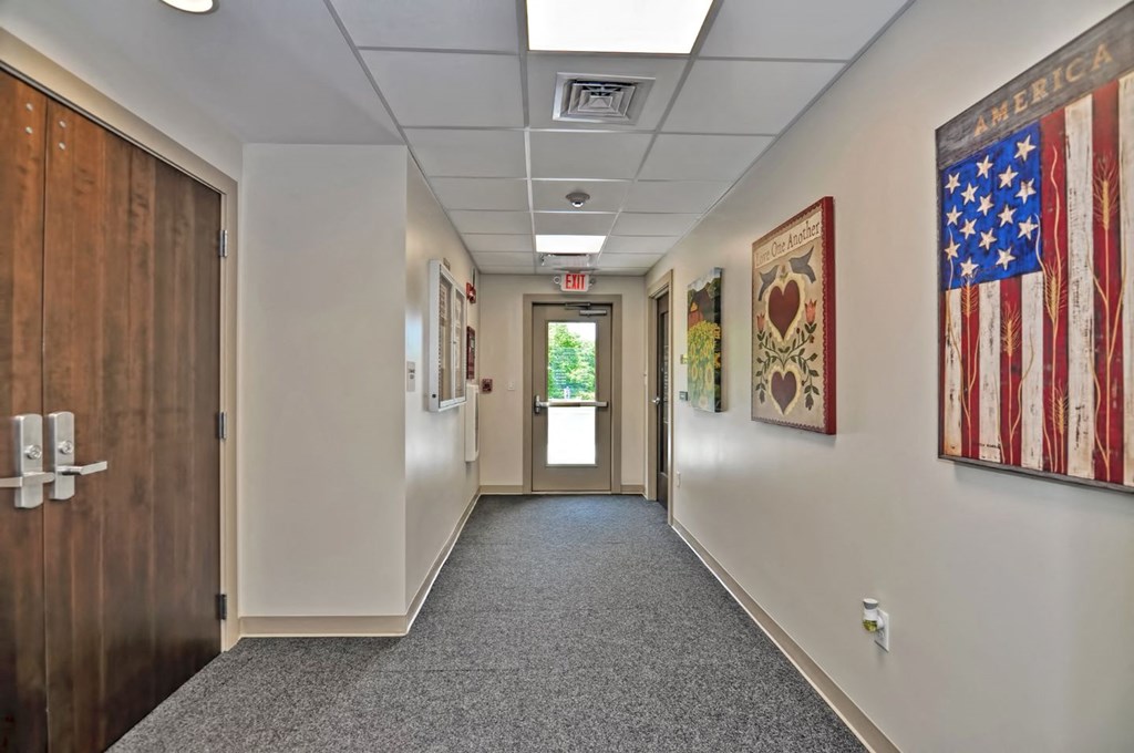 a hallway with a door and flags hanging on the walls