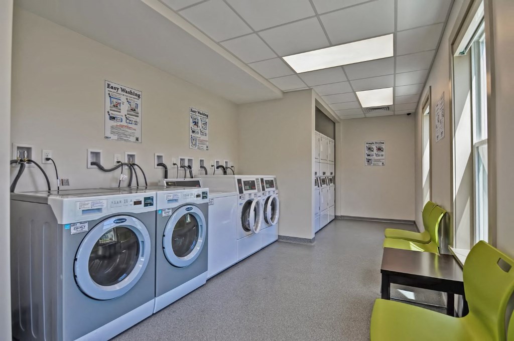 a washer and dryer room with a row of washing machines