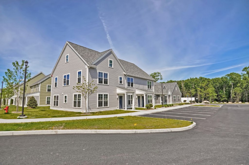 a row of houses on a street with a parking lot