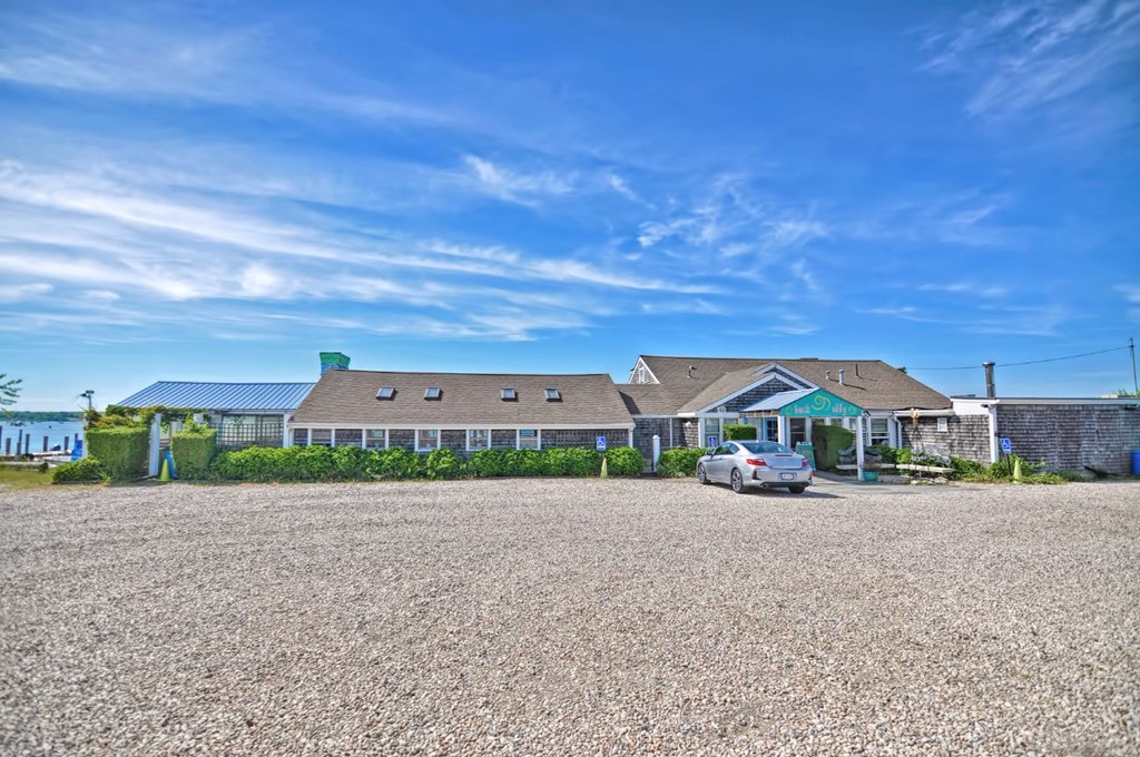 a house with a gravel driveway and a car parked in front of it