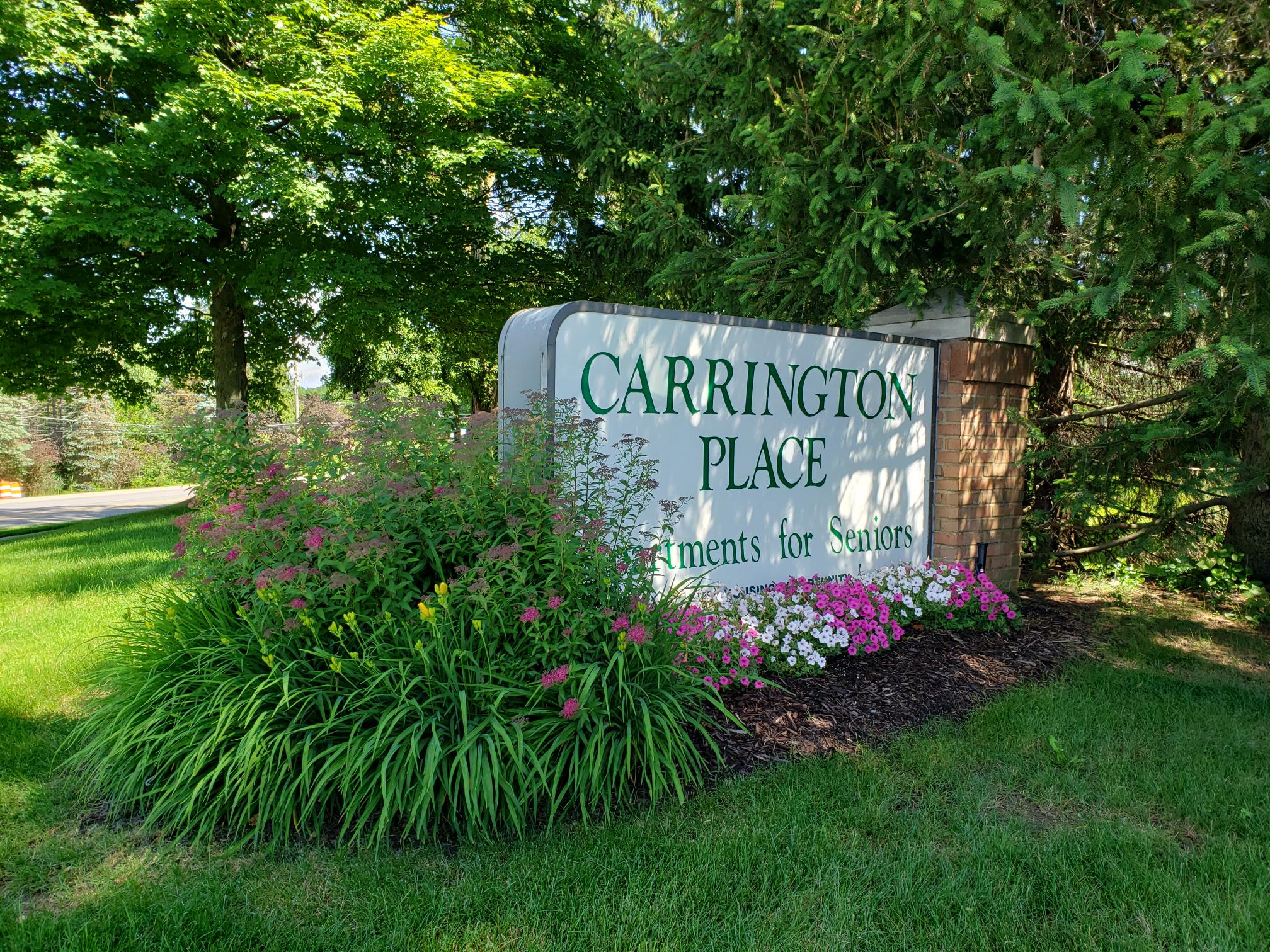 a sign in front of flowers and trees
