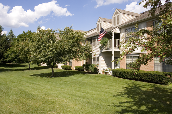 a lawn in front of an apartment building with an flag
