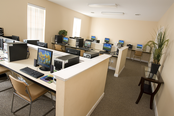 an empty computer room with many computers and desks