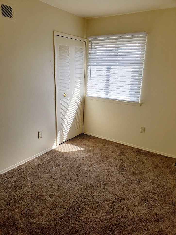 an empty room with a door and a window