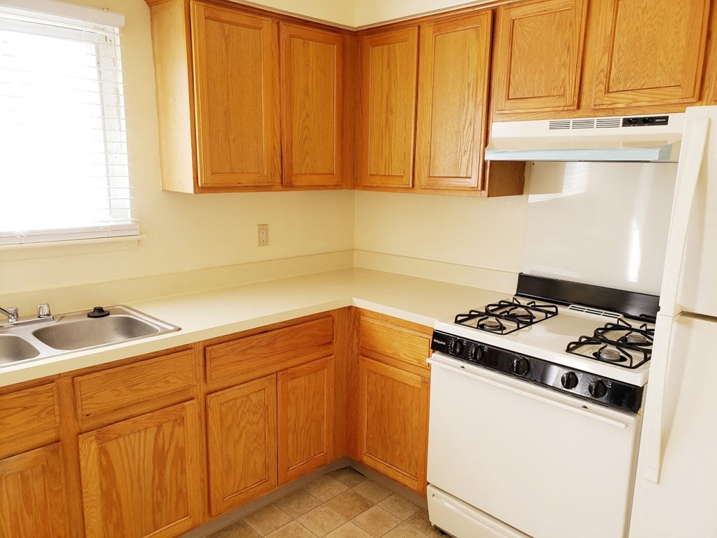 a kitchen with white appliances and wooden cabinets