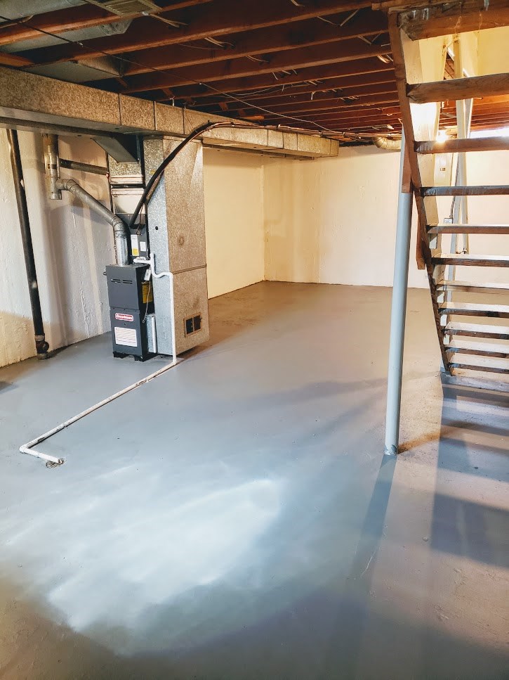 a basement with a painted floor and a staircase