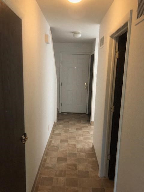 a hallway with a white door and a tile floor