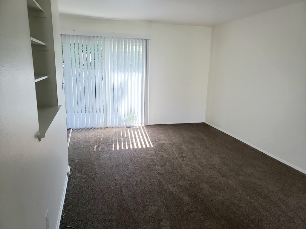 an empty living room with a sliding glass door