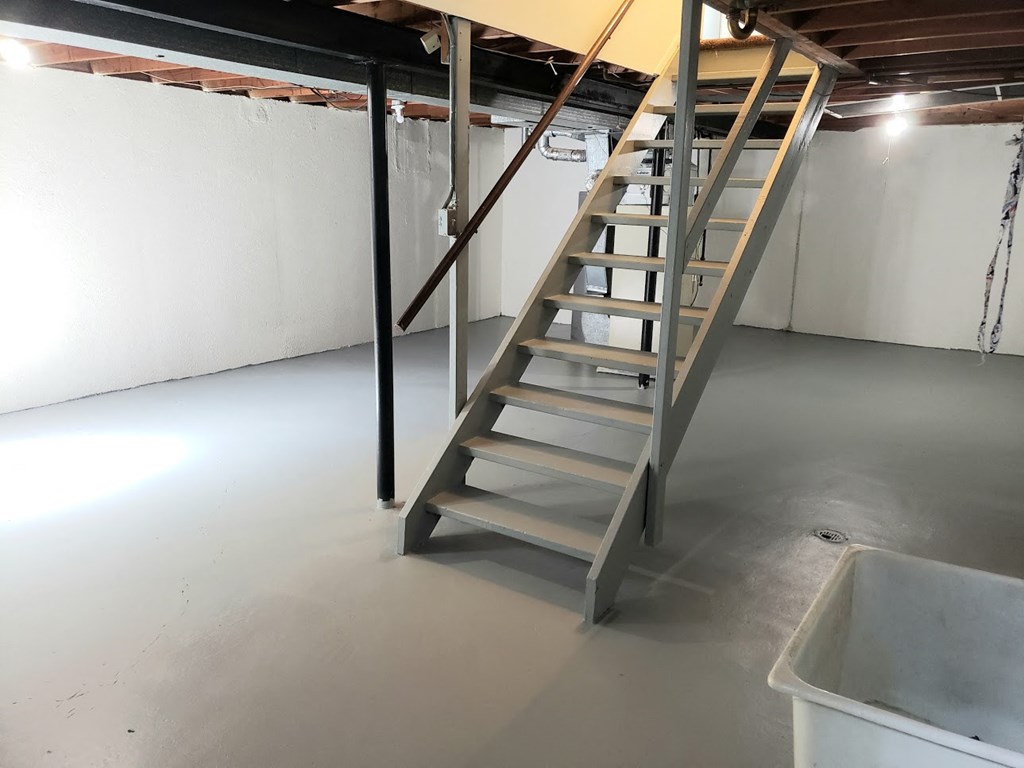 a ladder in a garage with a white floor and white walls