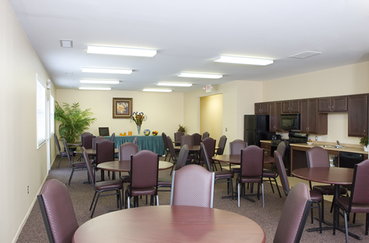 a dining room with tables and chairs and a kitchen