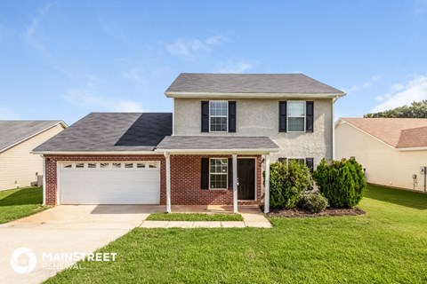 a brick house with a lawn and a white garage door