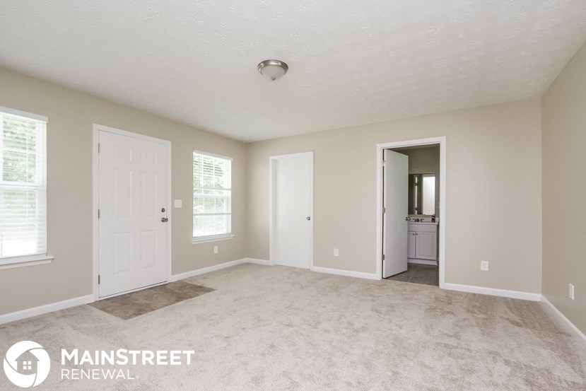 a master bedroom with a carpeted floor and white doors