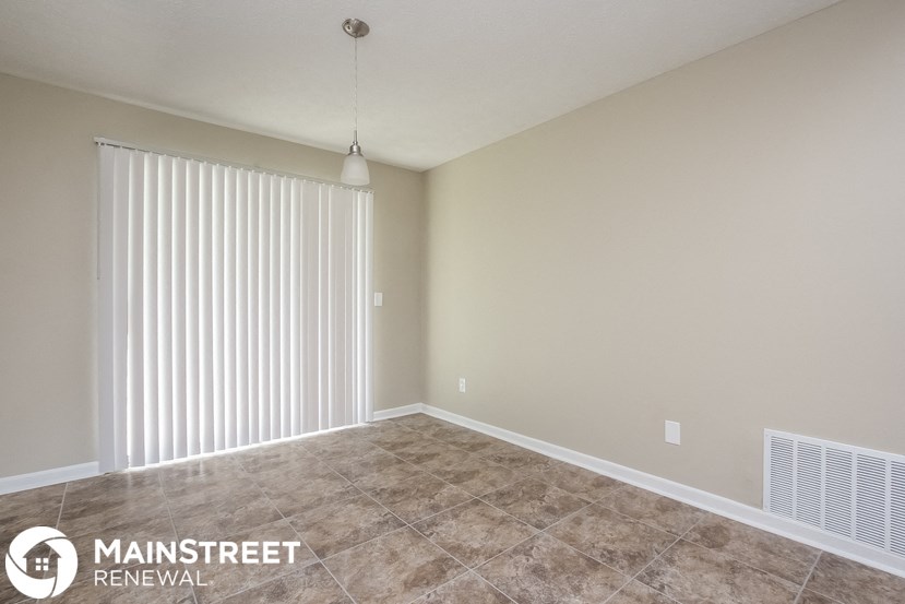 an empty living room with a large white blinds on the window