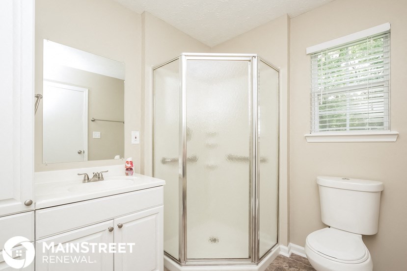 a bathroom with a shower and a sink and a toilet