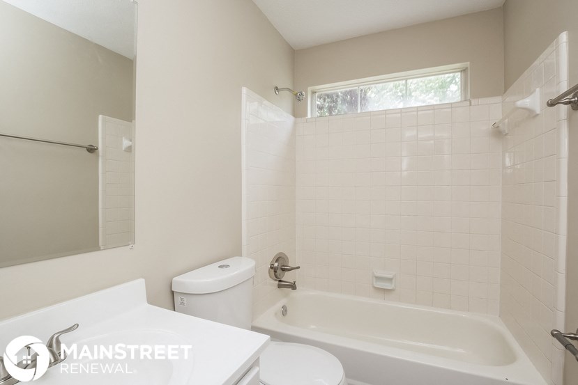 a white bathroom with a tub and a toilet and a sink