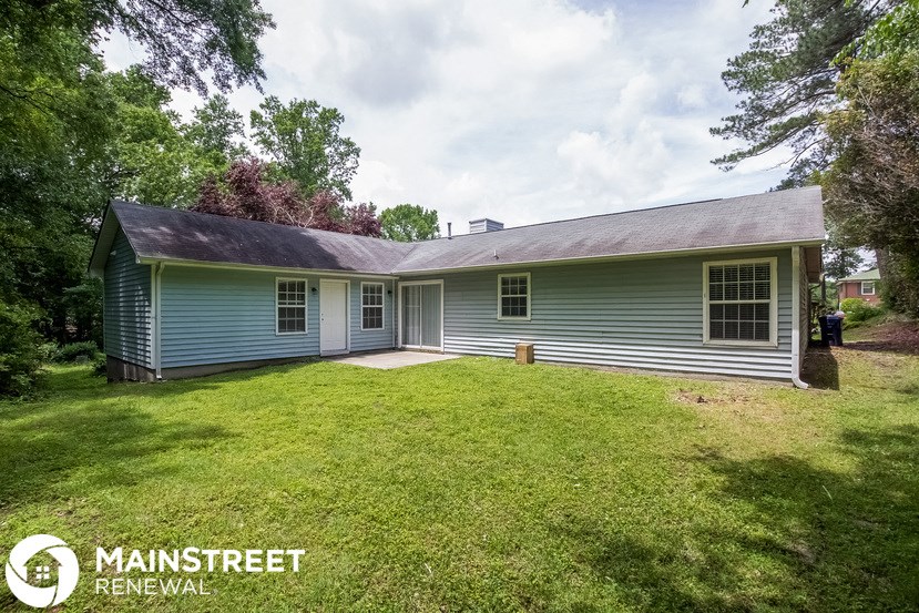 the front of a blue house with a grassy yard