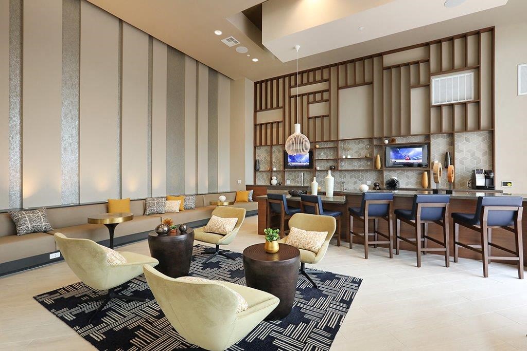 the lobby of a hotel with a bar and chairs