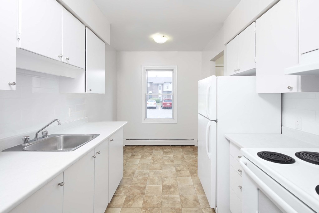 a white kitchen with white appliances and white cabinets