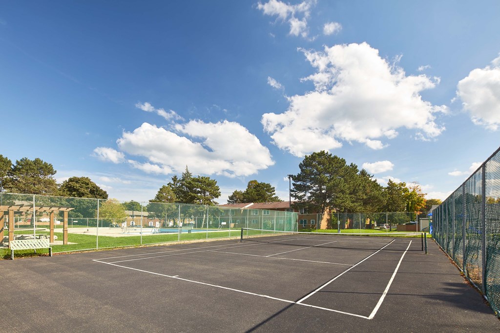 a tennis court with a fence around it on a sunny day
