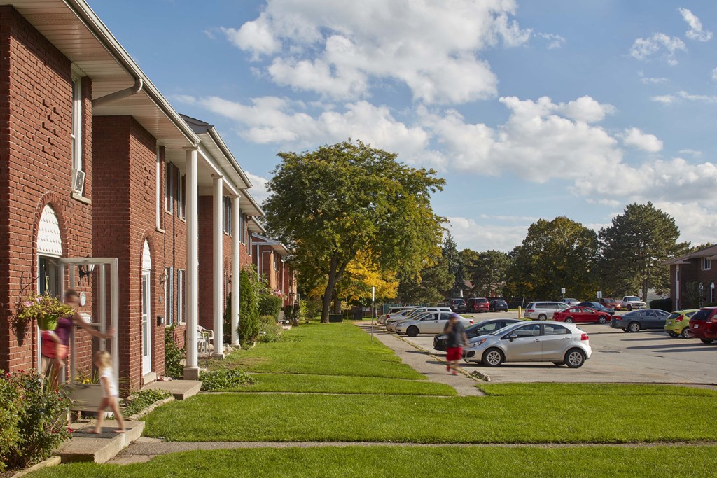 a city street with cars parked in front of houses