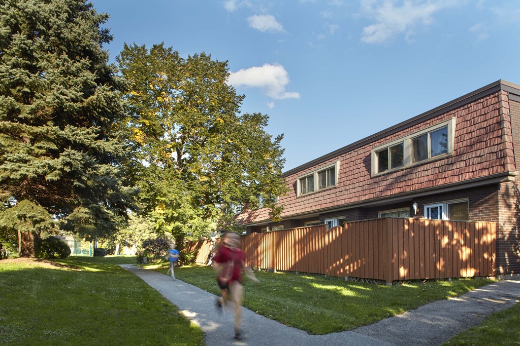 a person running down a sidewalk in front of a house