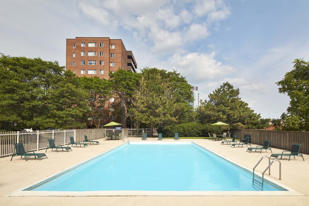 a swimming pool at a hotel with chairs around it