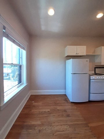 a kitchen with a white refrigerator and a window