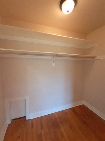 a living room with a wooden floor and a white wall
