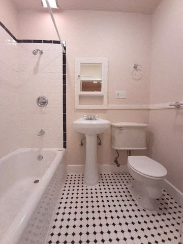 a bathroom with a toilet and a sink and a bath tub