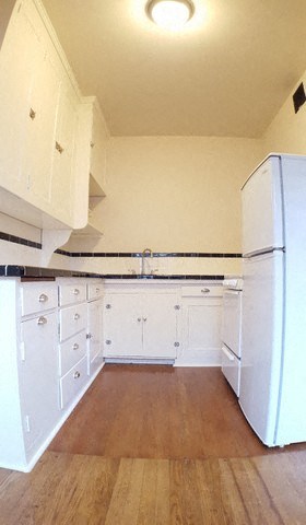 a kitchen with white cabinets and a refrigerator