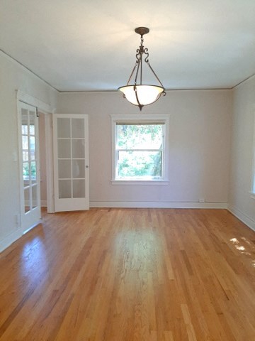 an empty living room with a wooden floor and a window