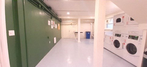 a laundry room with two washing machines and green doors