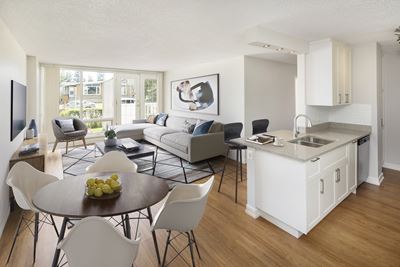 Dining room and living room with a dining table, countertop and sink, and a couch