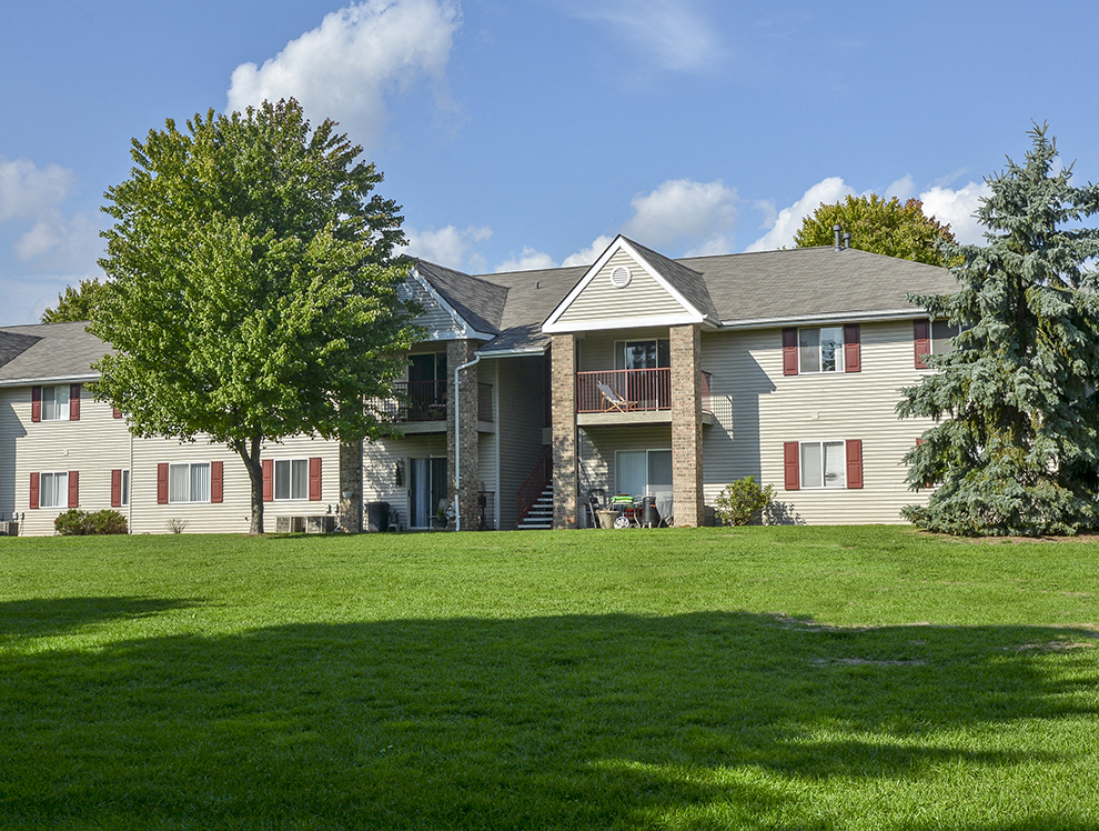 Lush Green Grass and Trees in Front Of a Turtle Cove Apartment Building
