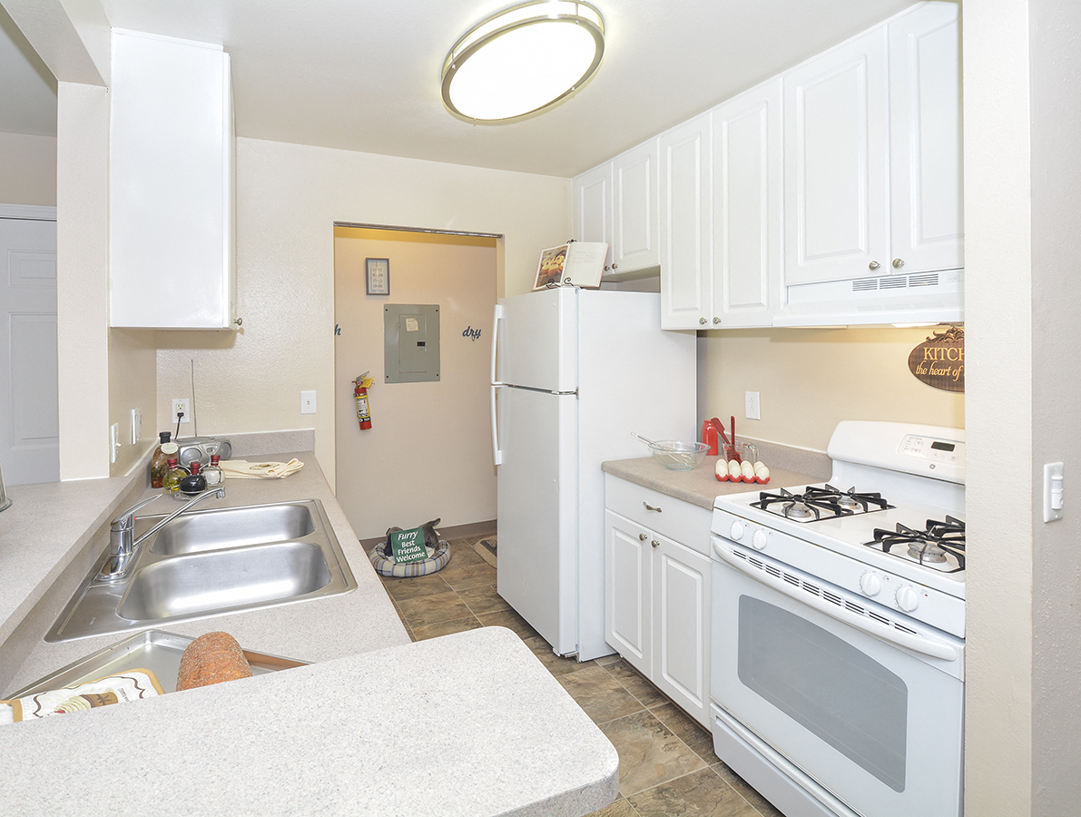 Kitchen with White Cabinetry and Appliances with Light Countertops