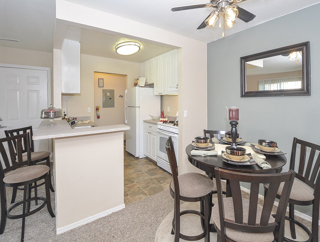 a dining room and kitchen with a table and chairs