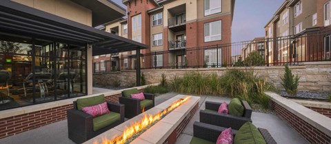 a patio with chairs and a fire pit